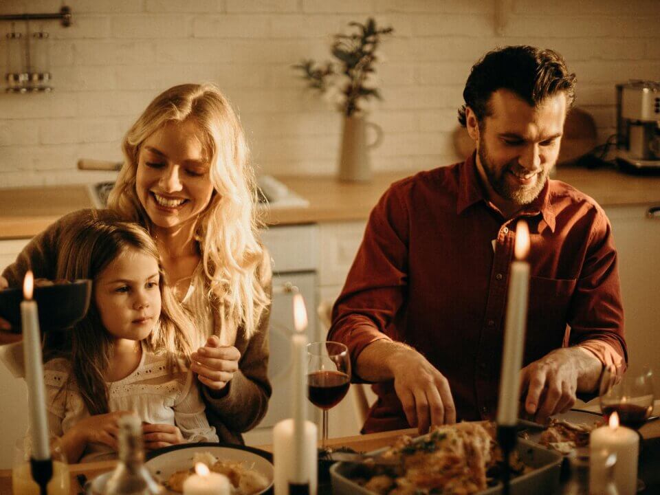 couple sitting at table with young daughter